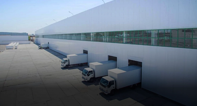 Warehouse with trucks representing trade, production, and distribution logistics